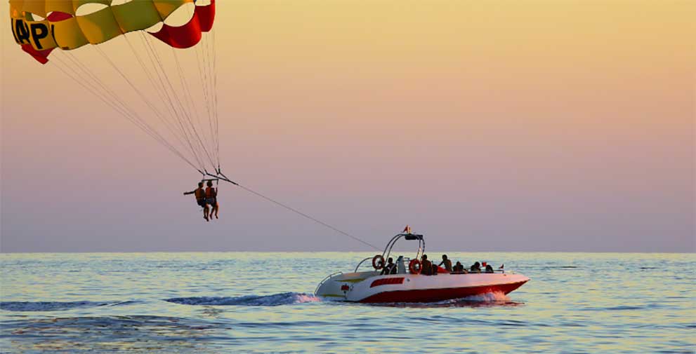 boat towing two people parasailing